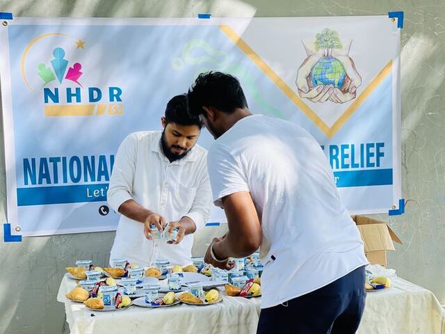 Volunteers preparing food plates for a school distribution