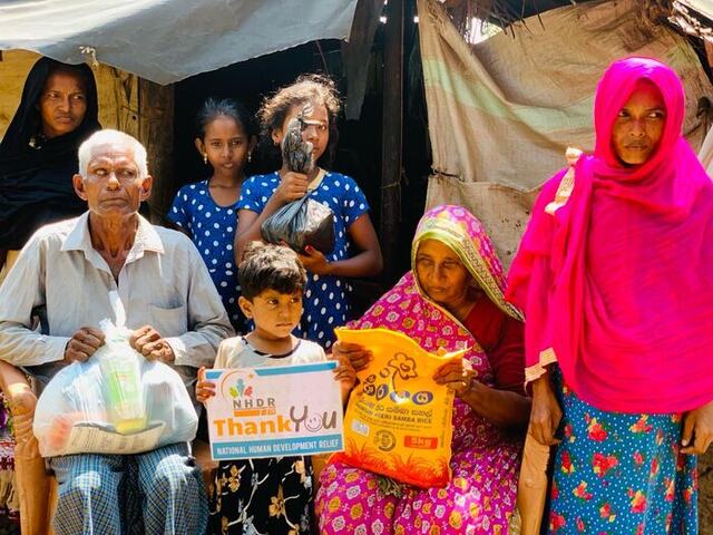 Three generations of a family receiving a rice bag from NHDR