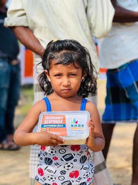 A young girl holding an emergency response food box